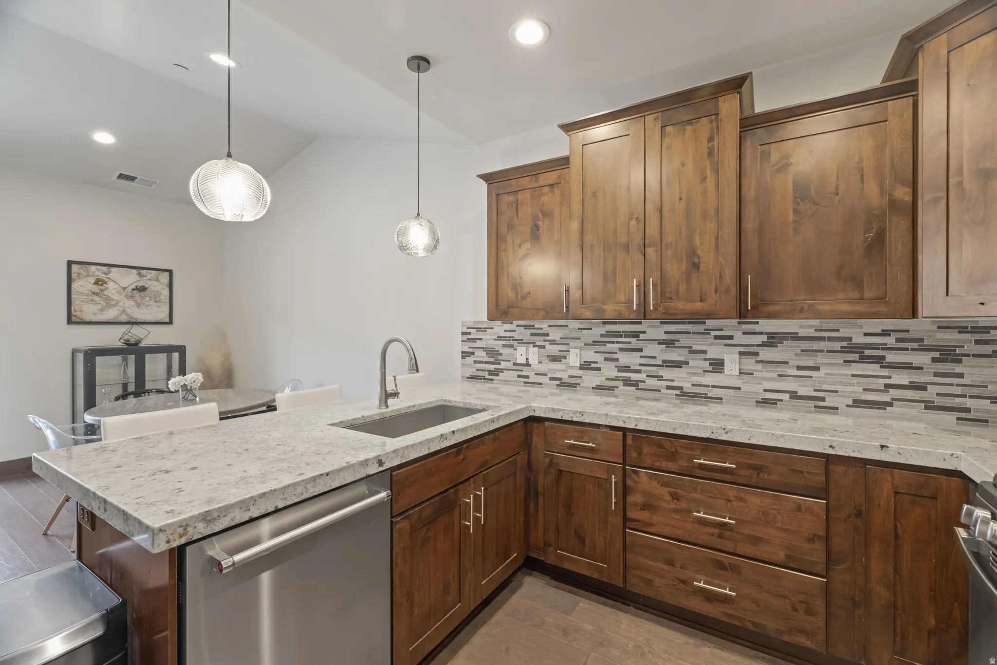 Kitchen featuring wood-finish cabinetry, light-toned countertops, and a mosaic tile backsplash