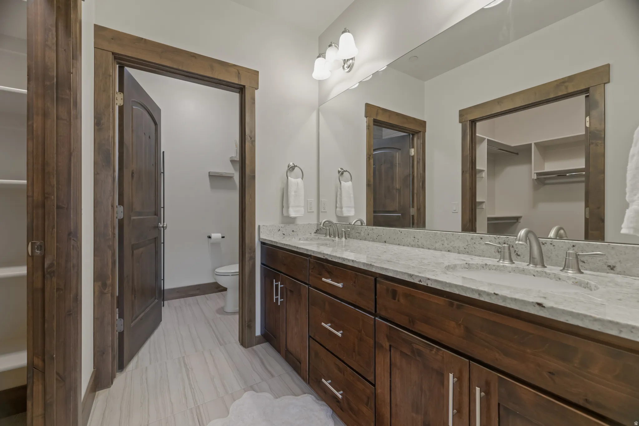 Double vanity with undermount sinks and light-colored stone countertops