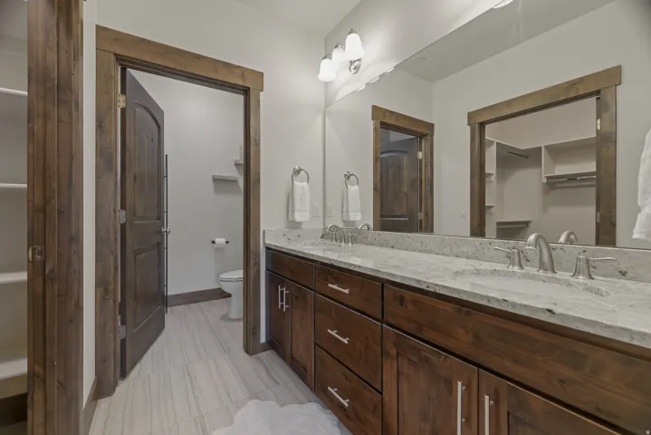Double vanity with undermount sinks and light-colored stone countertops