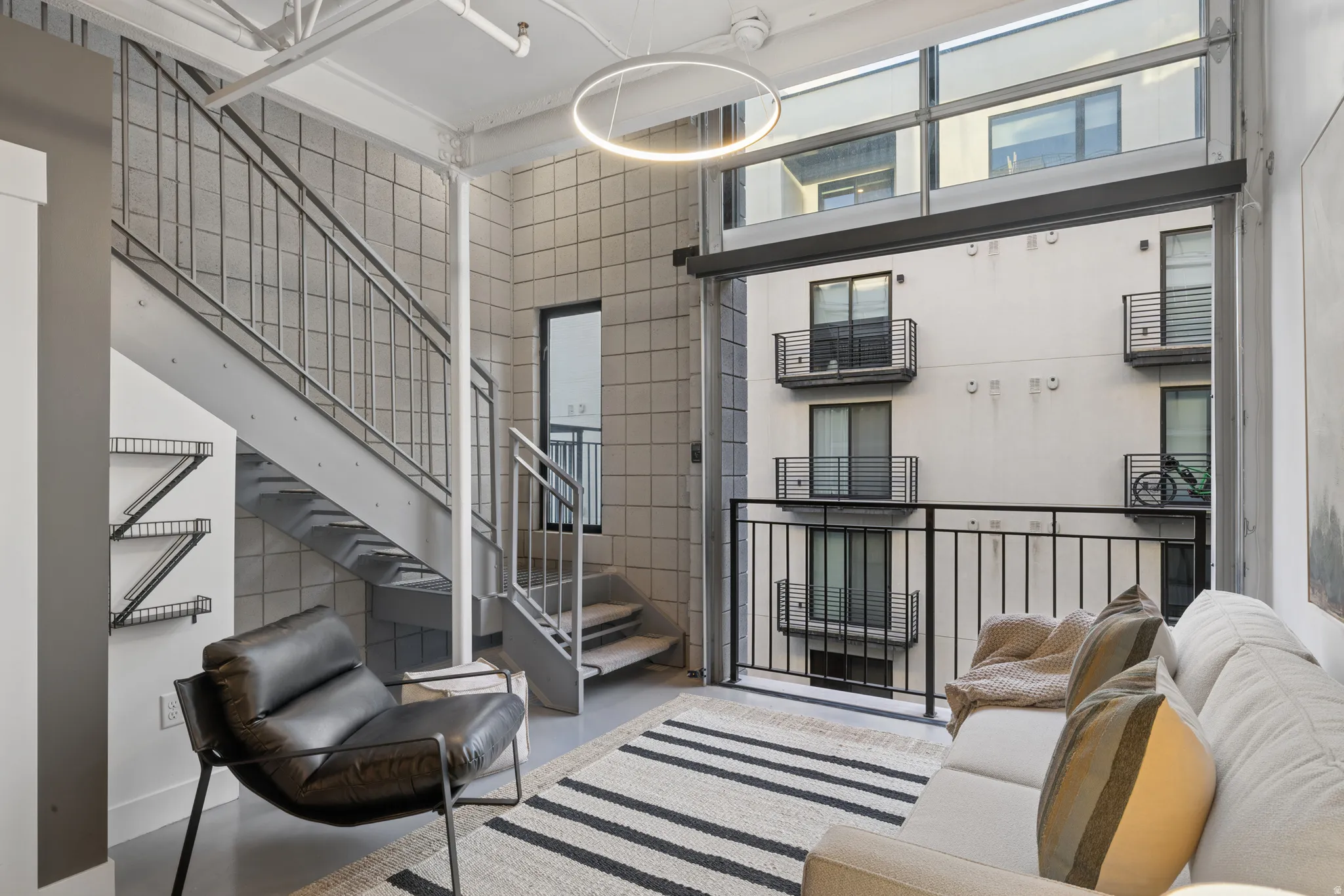 Two-story window wall with transom windows and direct access to an exterior balcony