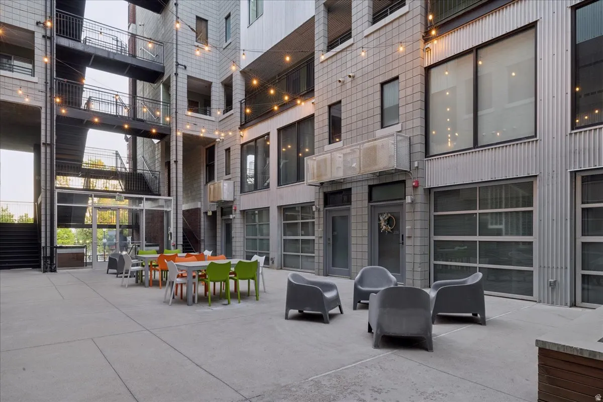 Courtyard featuring a concrete patio, multiple seating arrangements, and string lighting