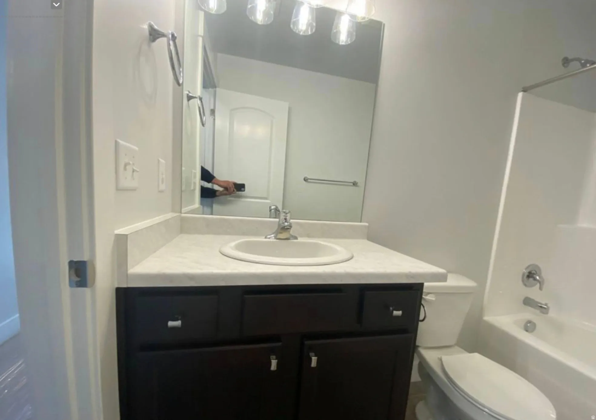 Bathroom vanity featuring a light-toned countertop, integrated sink, and dark wood-finish cabinetry