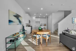Open-concept main living area with wood-finish flooring, white walls, and recessed lighting
