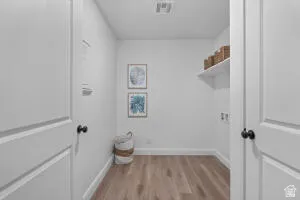 Dedicated utility space featuring wood-finish flooring, crisp white walls, and a recessed ceiling light