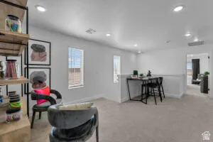 Open concept loft space with recessed lighting, carpet flooring, and multiple windows