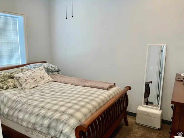 Bedroom featuring neutral wall paint, a window with blinds, and carpeted flooring