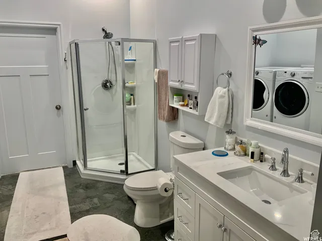 Bathroom featuring a contemporary shower enclosure, a vanity with a rectangular undermount sink, and a framed mirror