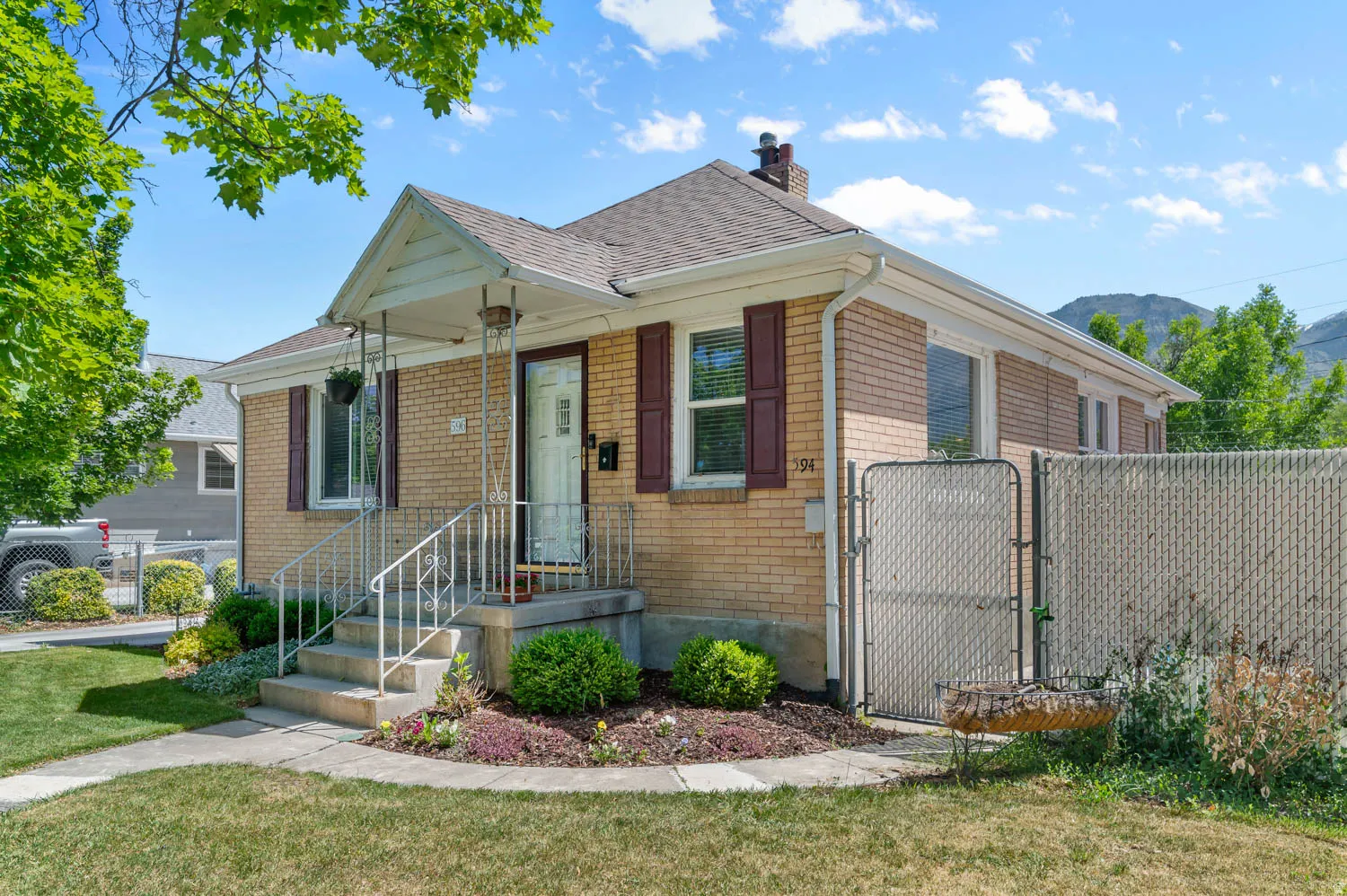Brick exterior with a covered front porch and wrought iron railings