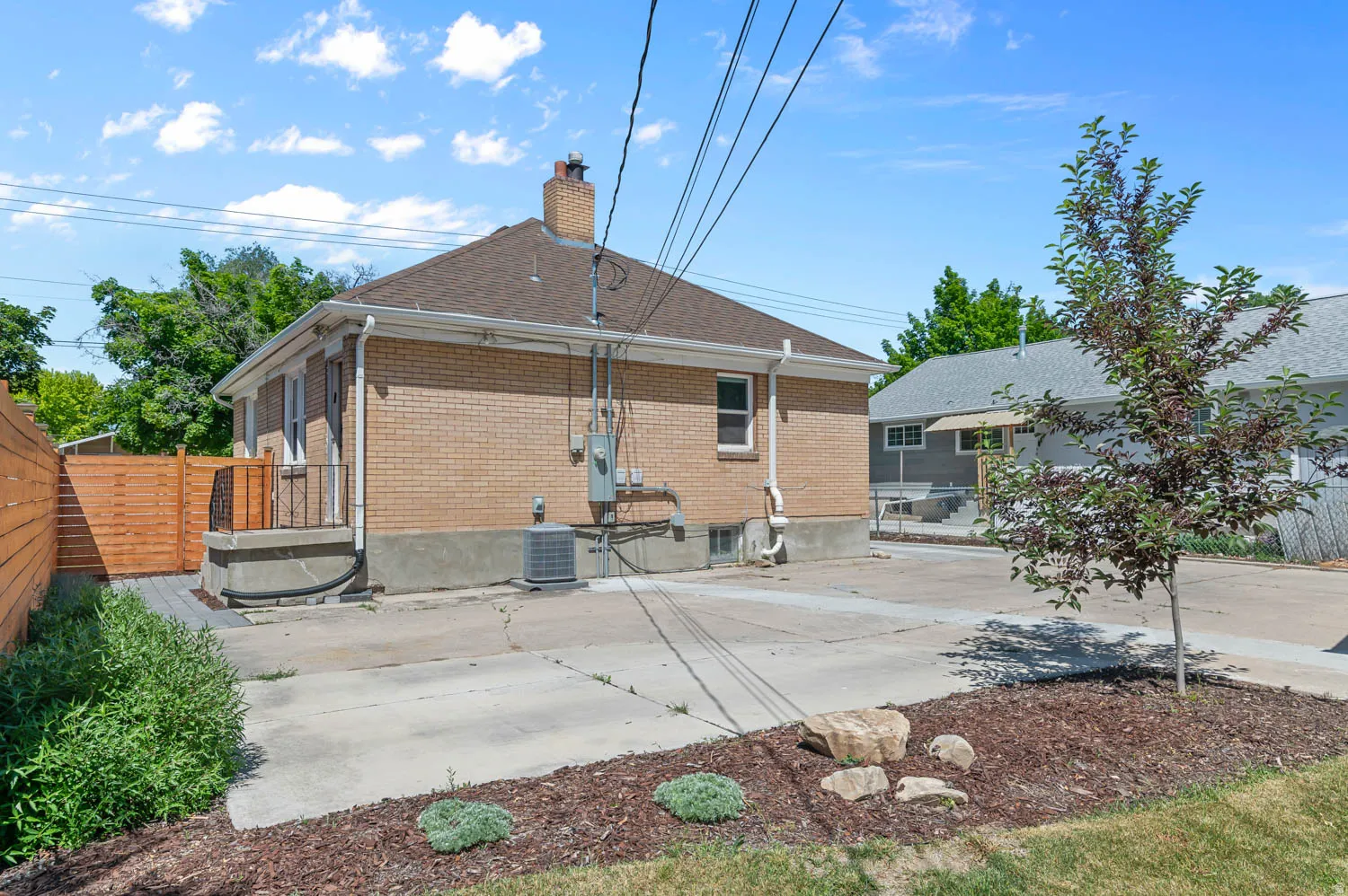 Brick exterior with a gabled roof and a concrete patio