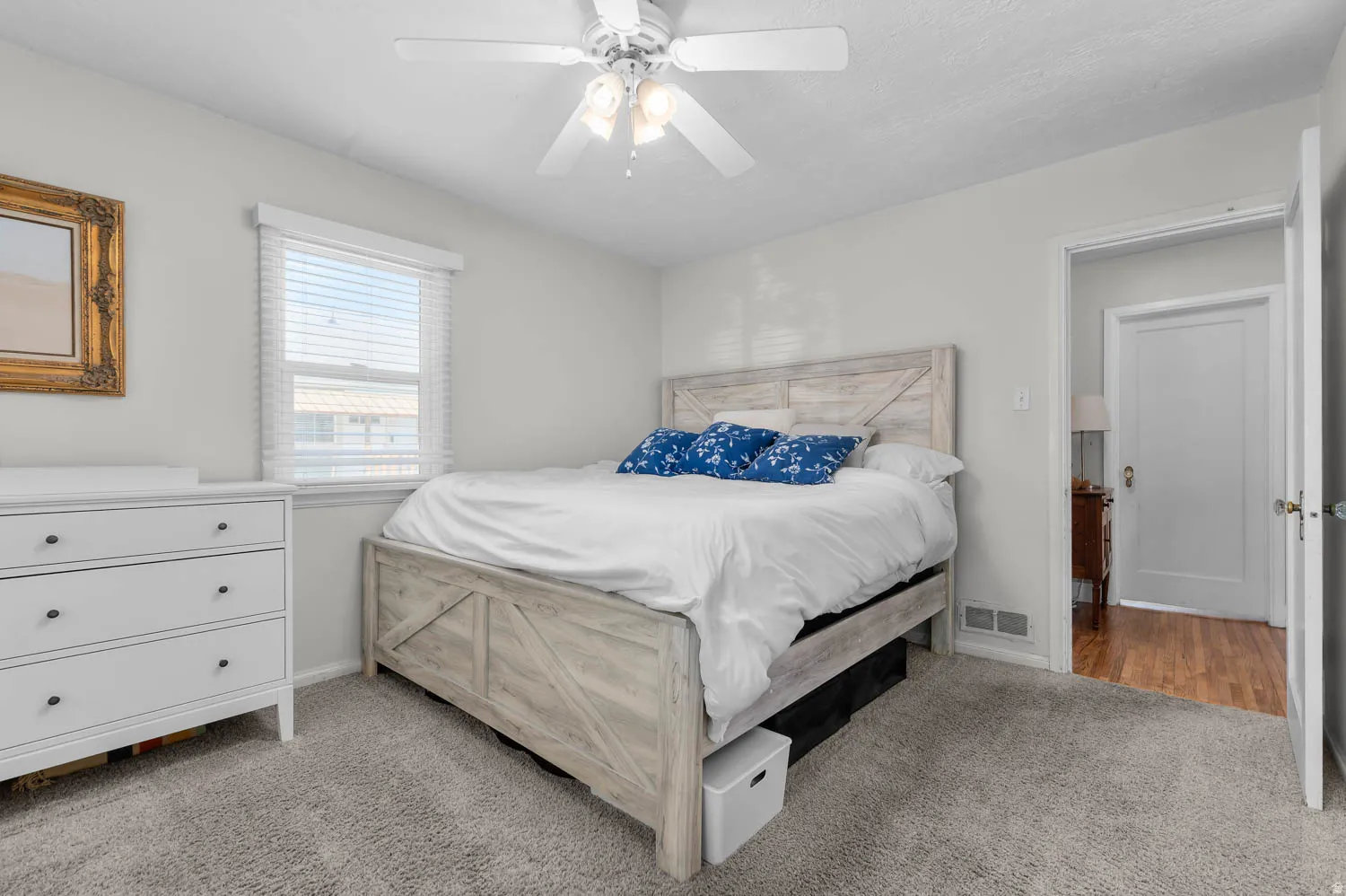 Bedroom featuring light gray wall paint, gray carpet flooring, a window with horizontal blinds, and a ceiling fan with light fixture