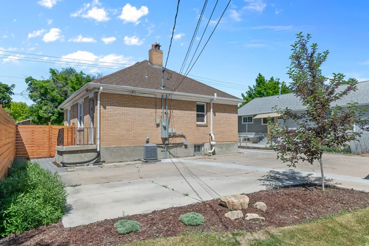 Brick exterior with a gabled roof and a concrete patio