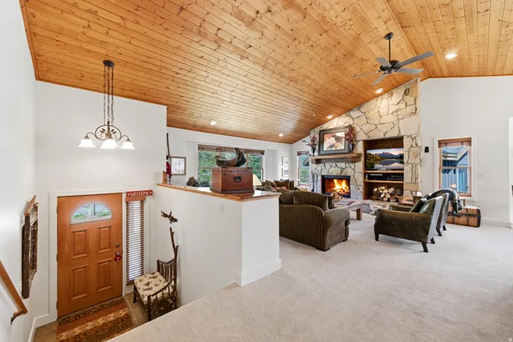 Vaulted wood-paneled ceiling with recessed lighting and a ceiling fan