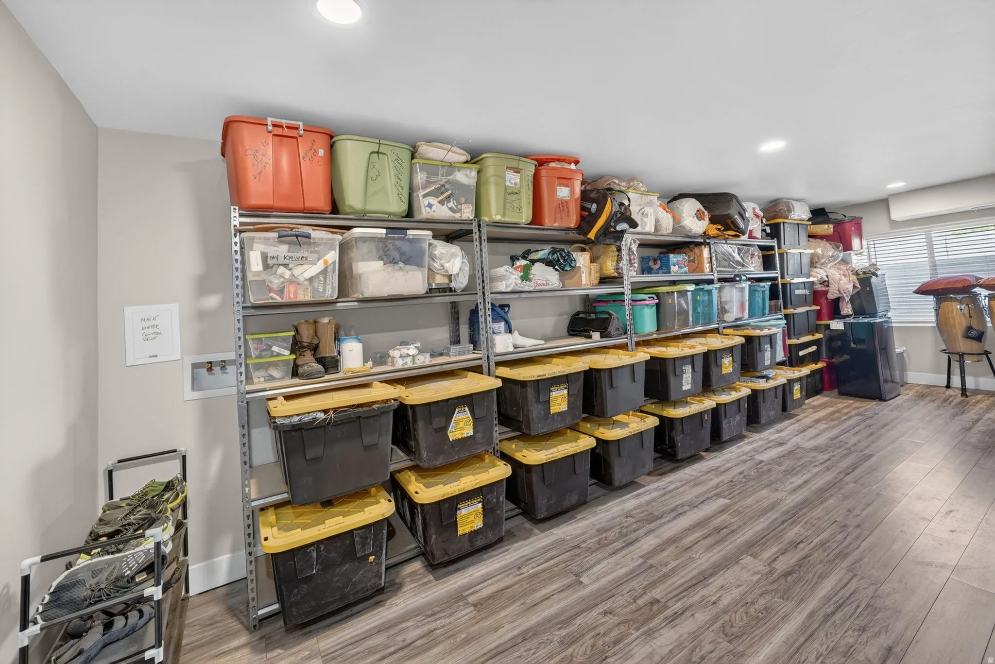 Dedicated storage area featuring extensive metal shelving units and wood-finish flooring