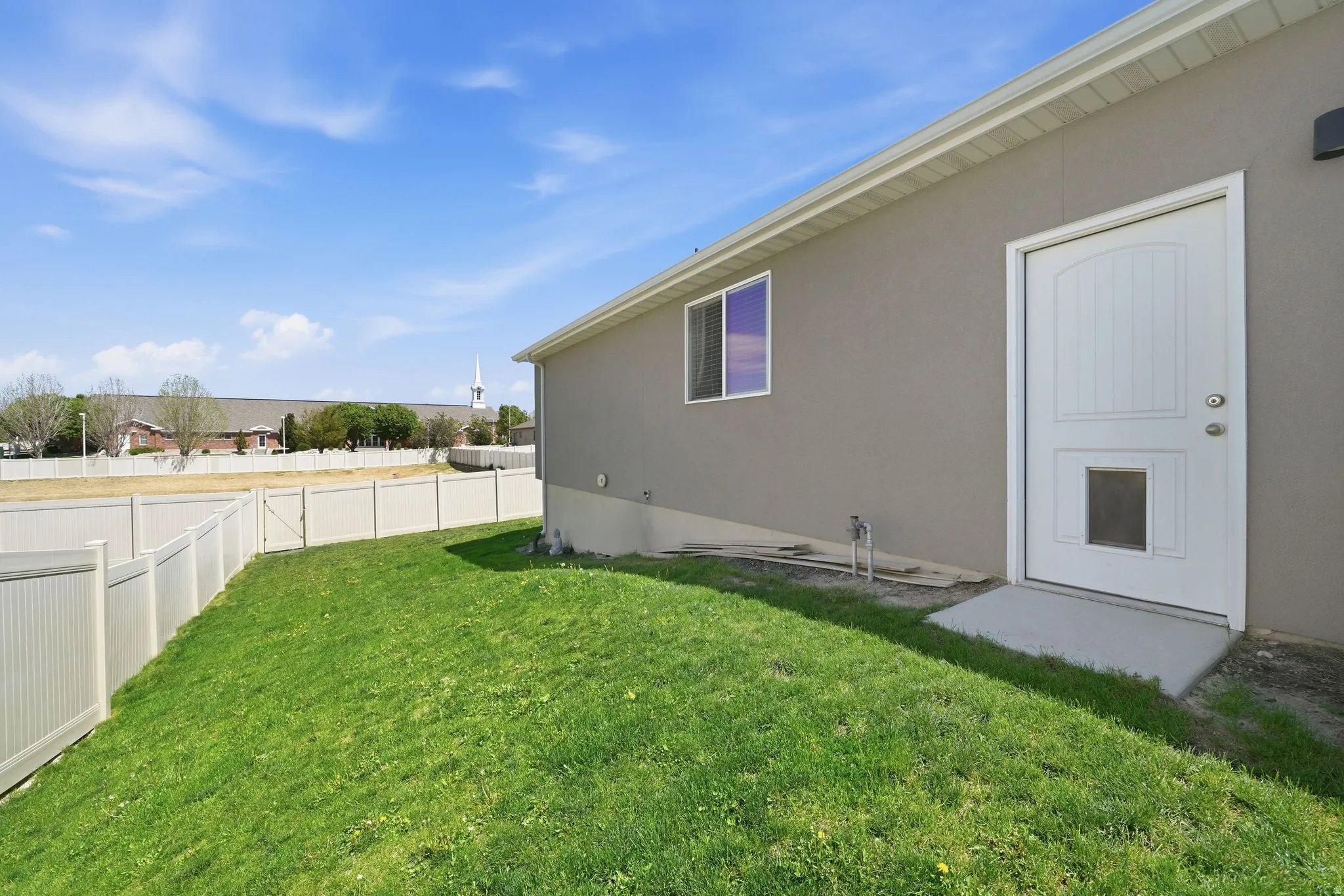 Expansive backyard featuring a manicured lawn and a full privacy fence