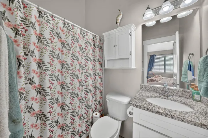 Bathroom vanity featuring a speckled countertop, a single basin sink, and a chrome faucet