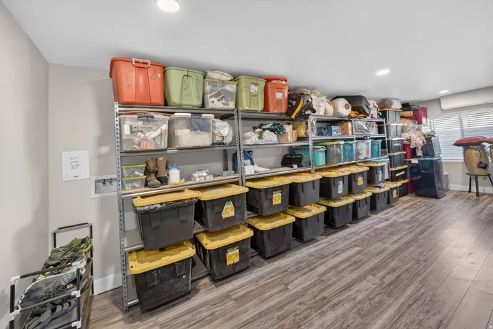 Dedicated storage area featuring extensive metal shelving units and wood-finish flooring