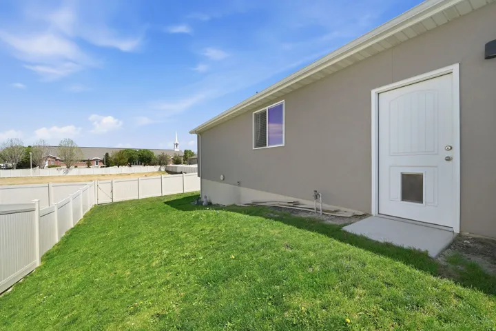 Expansive backyard featuring a manicured lawn and a full privacy fence