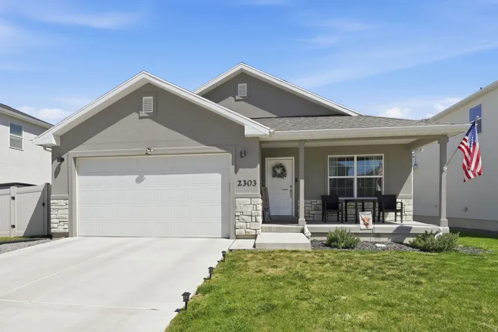 Contemporary stucco exterior with stone accents and an attached two-car garage