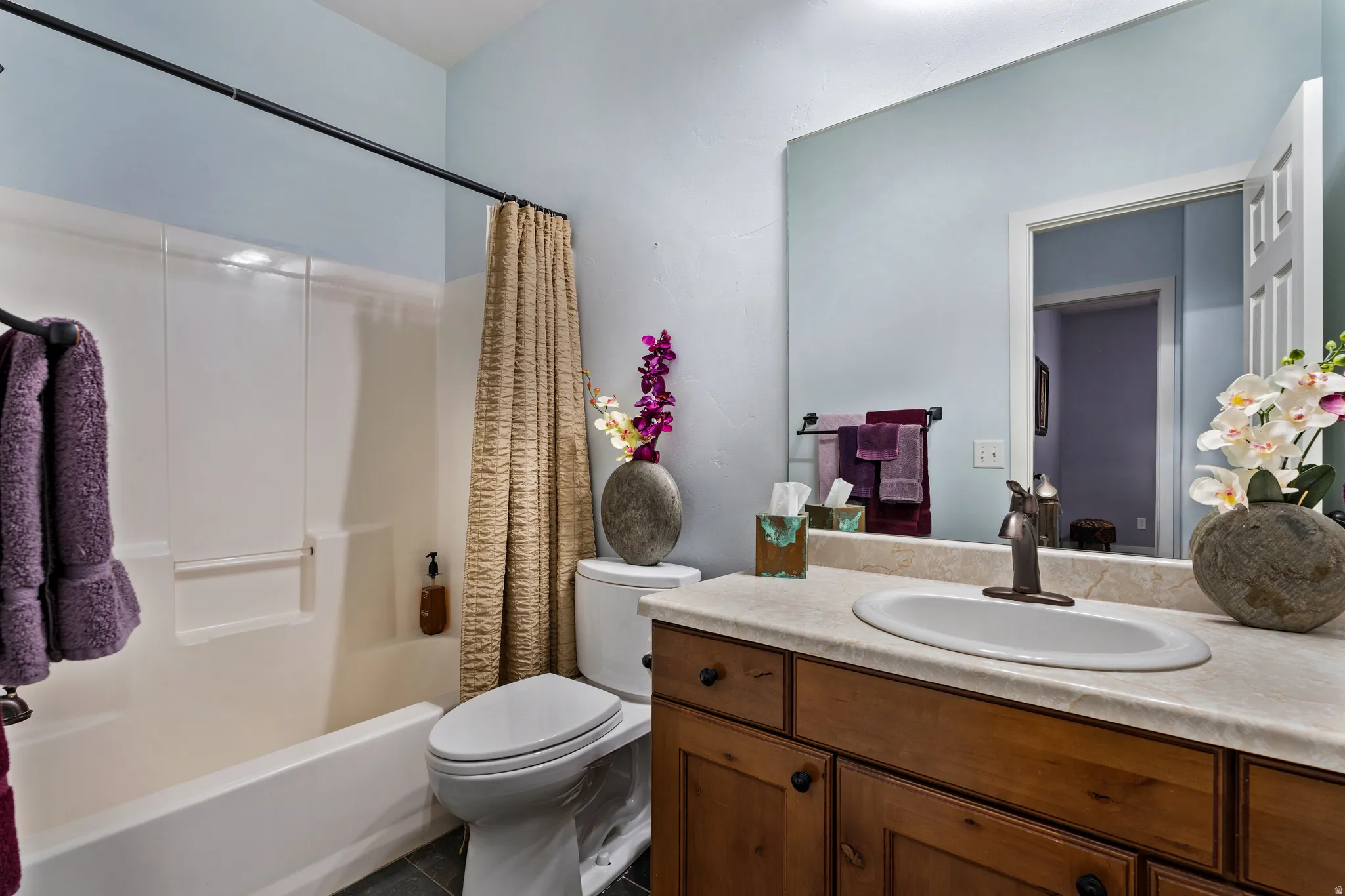 Bathroom featuring a shower-tub combination, a vanity with a light-colored countertop, and a built-in mirror