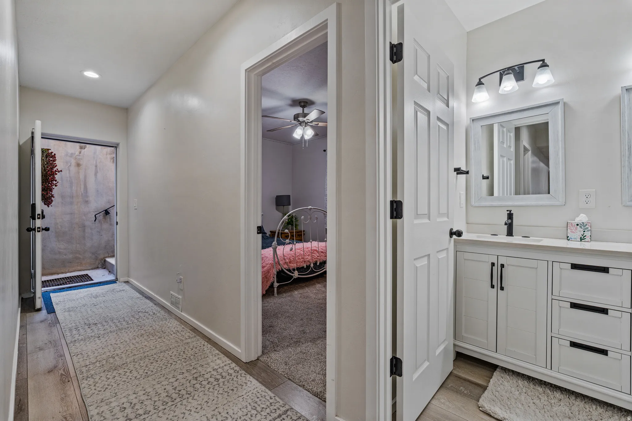 Hallway featuring wood-finish flooring, recessed lighting, and a neutral color palette