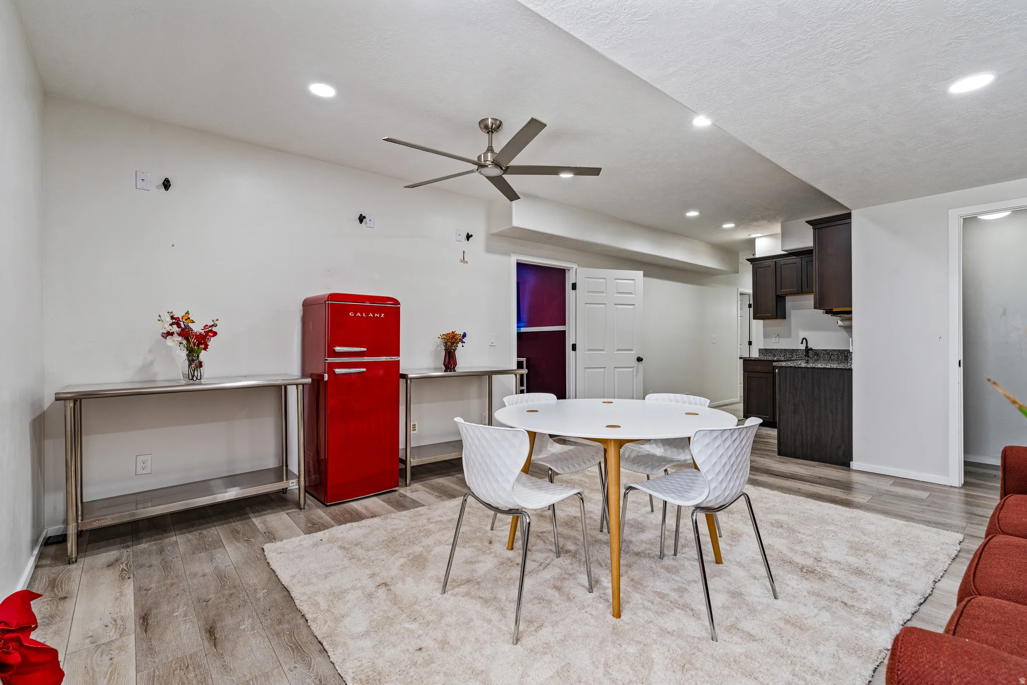 Open-concept living space featuring wood-finish flooring, recessed lighting, and a contemporary ceiling fan