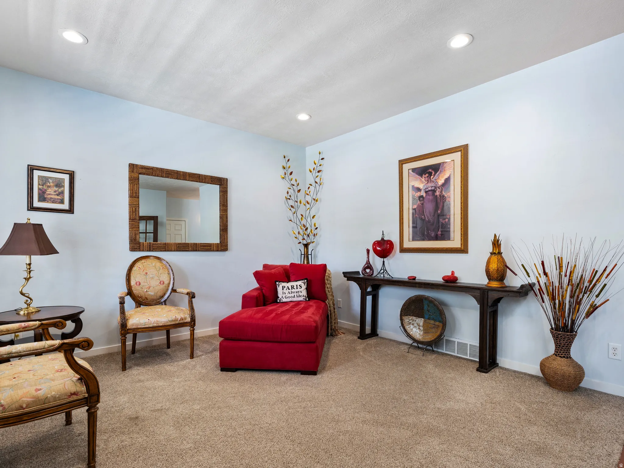 Carpeted living space with light blue walls, recessed lighting, and a console table