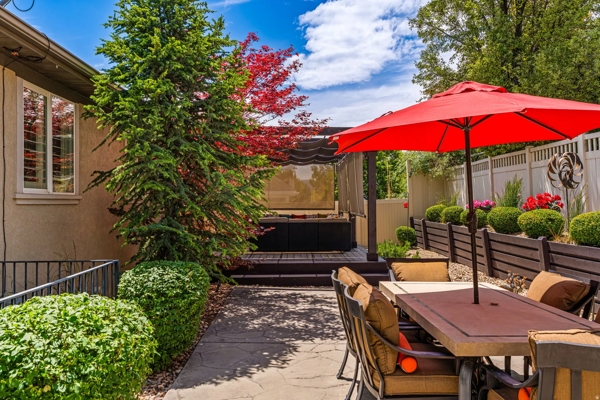 Expansive patio featuring a built-in spa, raised garden beds, and mature landscaping