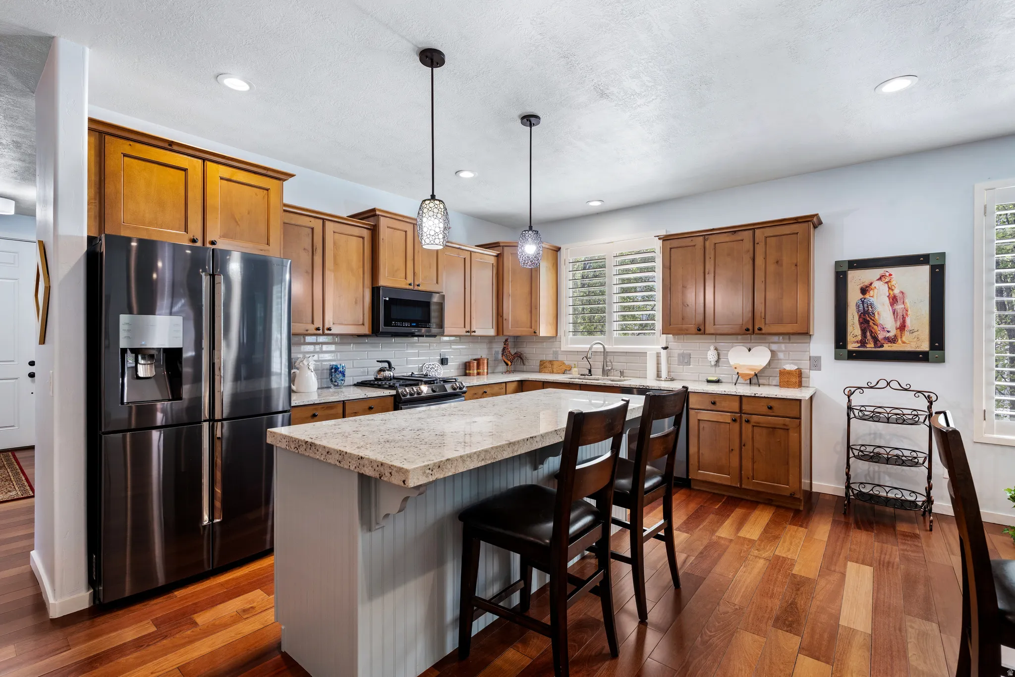 Kitchen featuring wood-finish flooring, recessed lighting, and a center island with bar seating