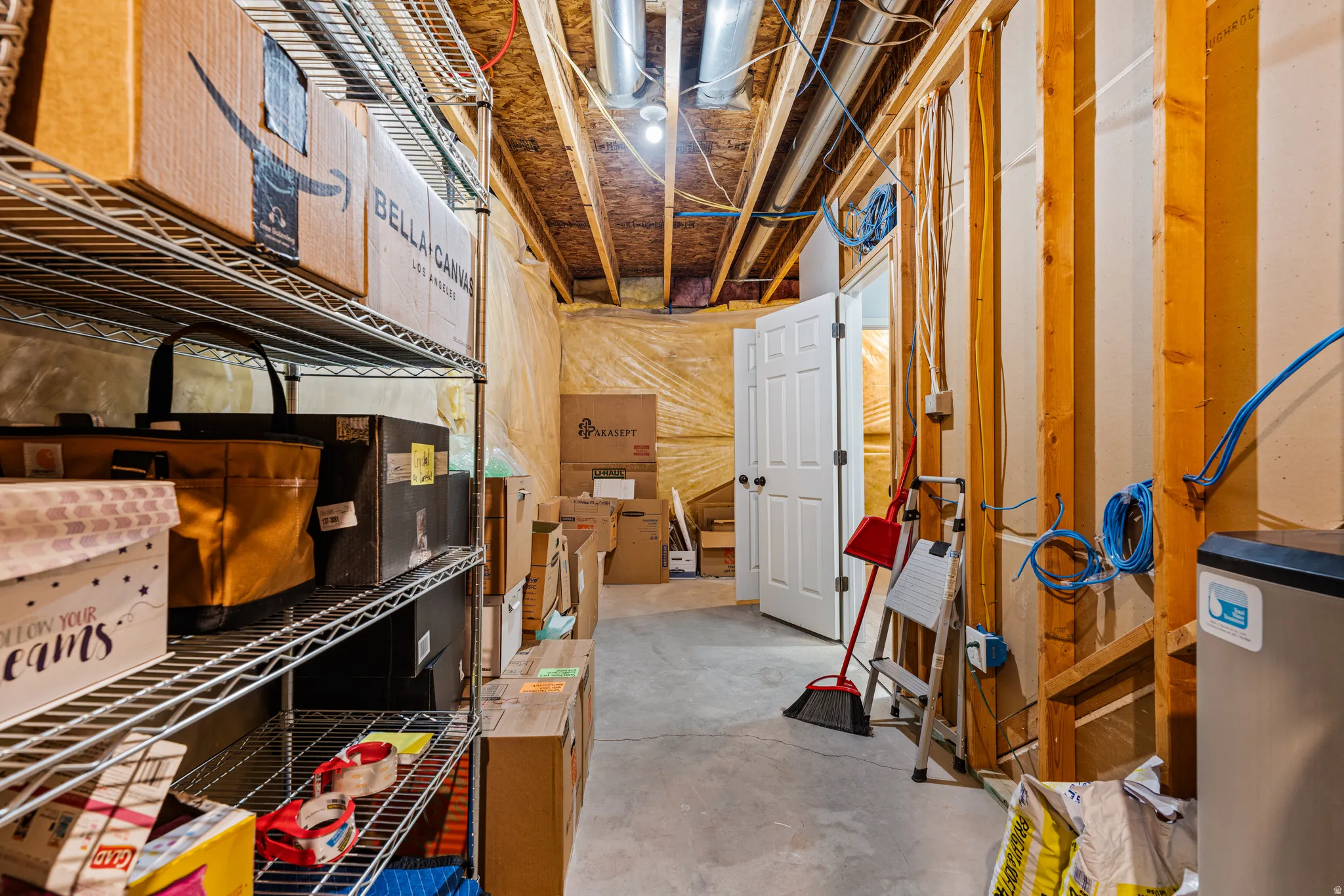 Unfinished basement area featuring exposed wood framing and a concrete floor