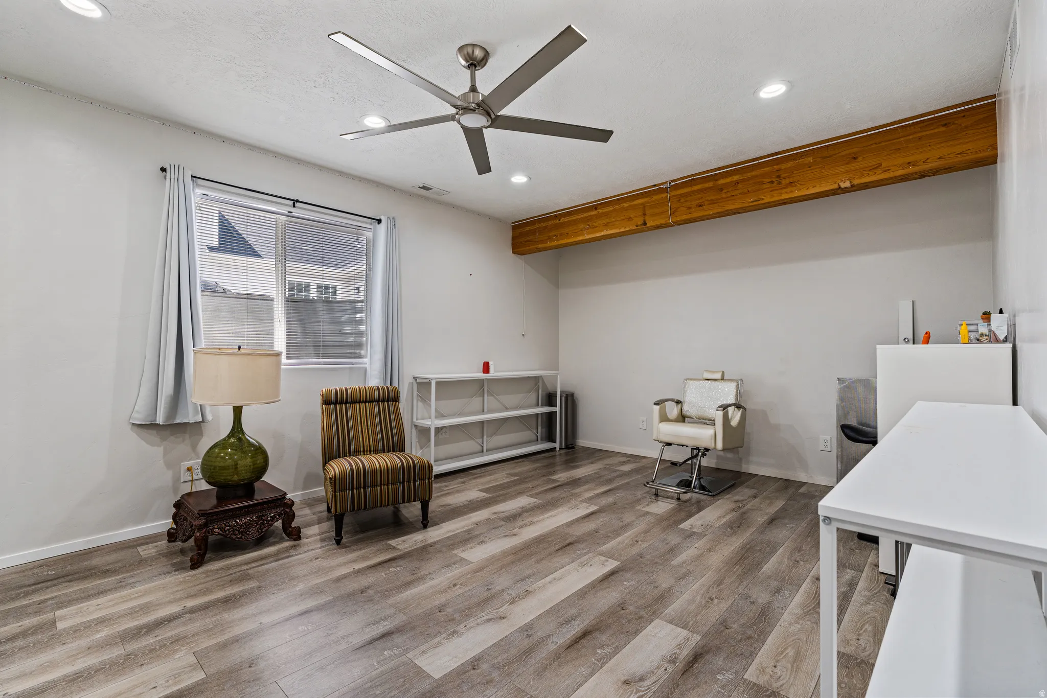 Spacious room featuring wood-finish flooring, recessed lighting, and a prominent ceiling fan