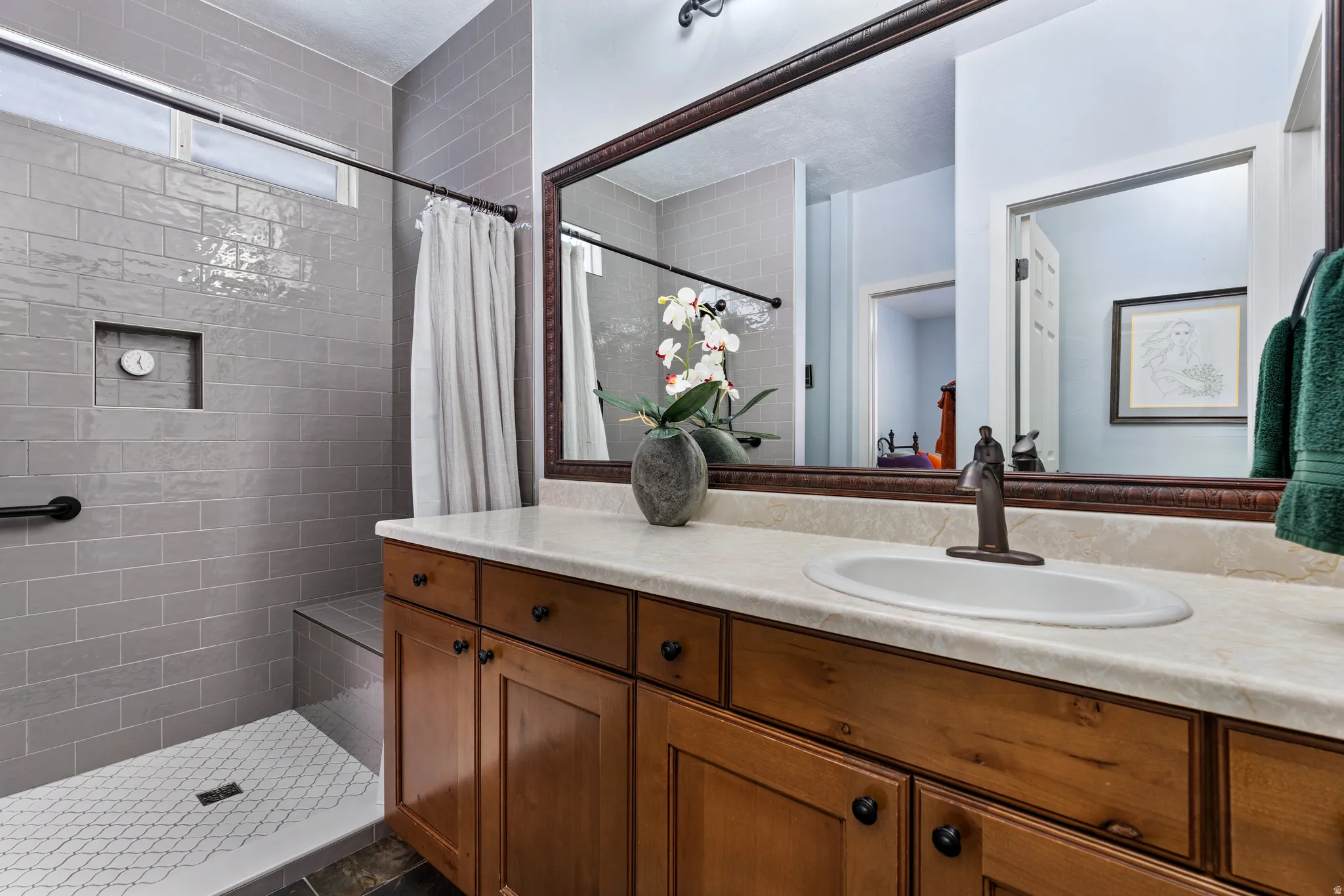 Bathroom with wood cabinetry vanity, integrated sink, and bronze-finish single-handle faucet