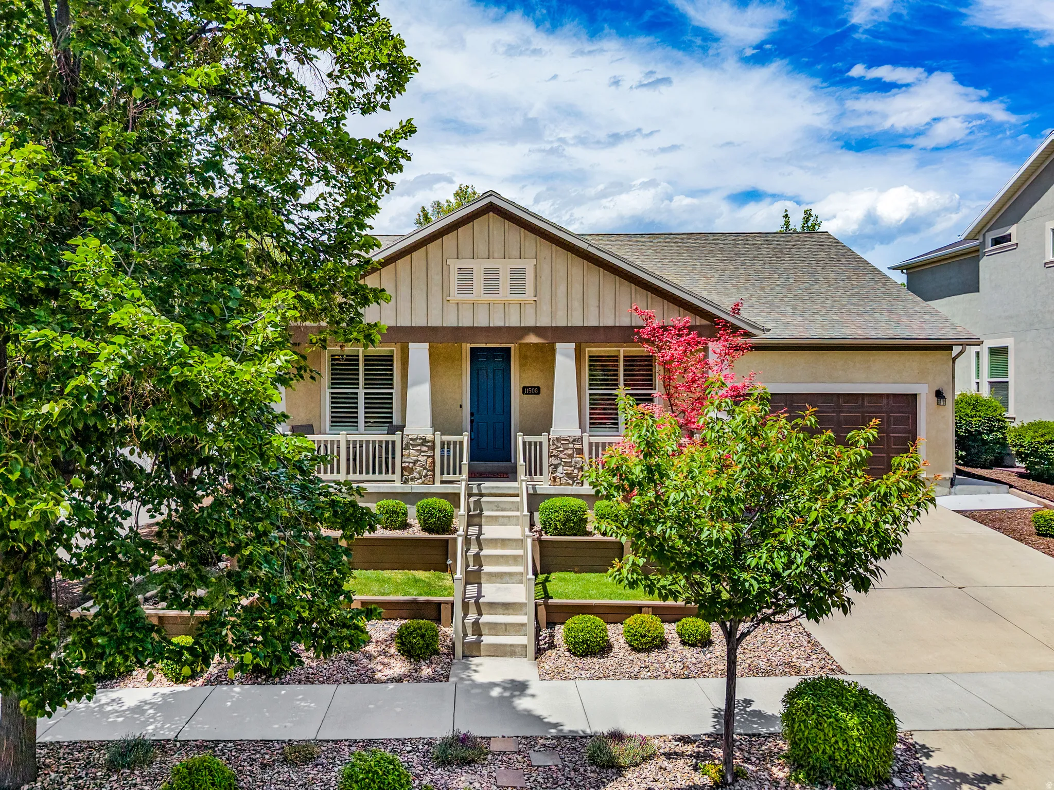 Craftsman-style facade with a covered porch featuring stone column bases and white railings