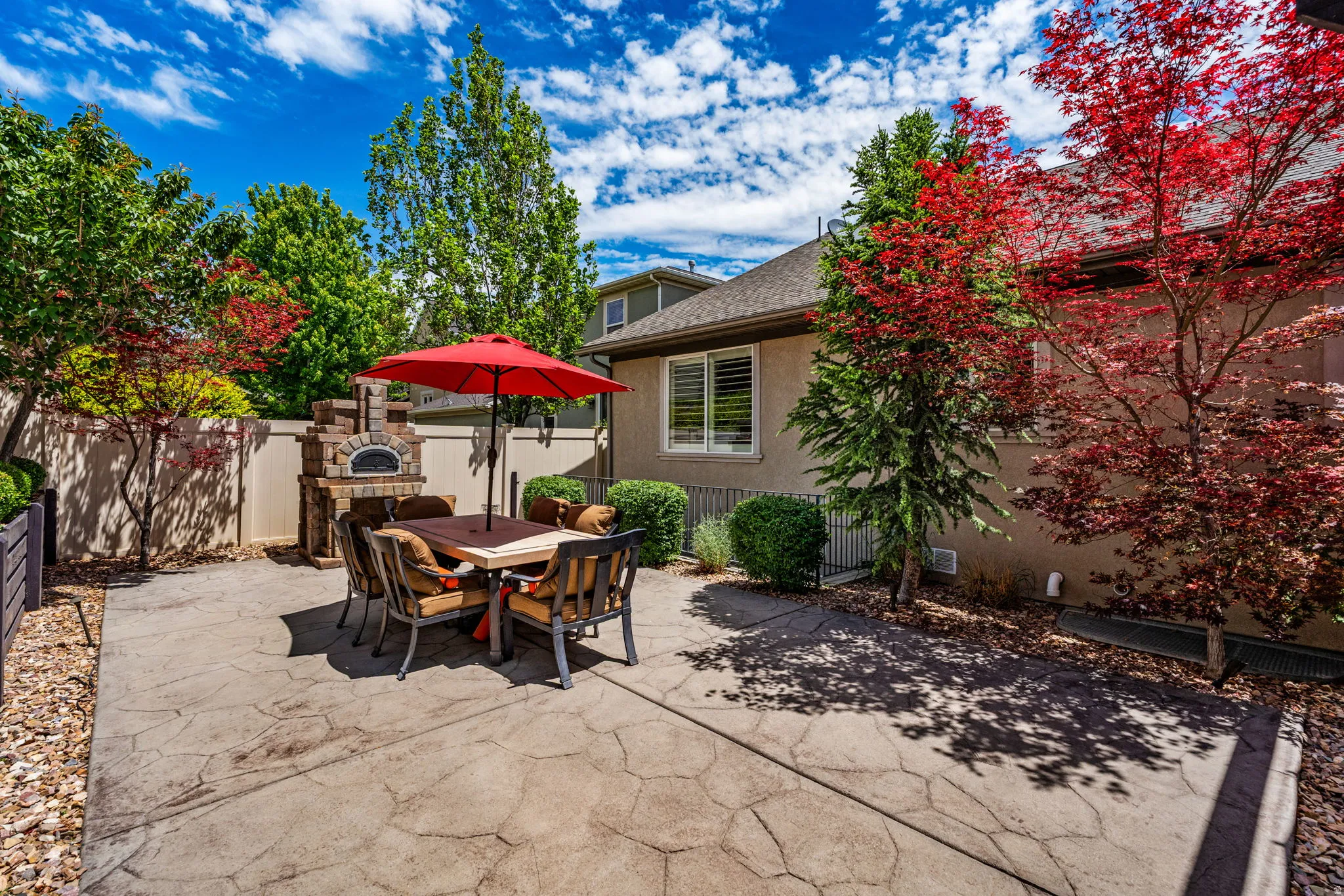 Stenciled concrete patio featuring a built-in brick pizza oven