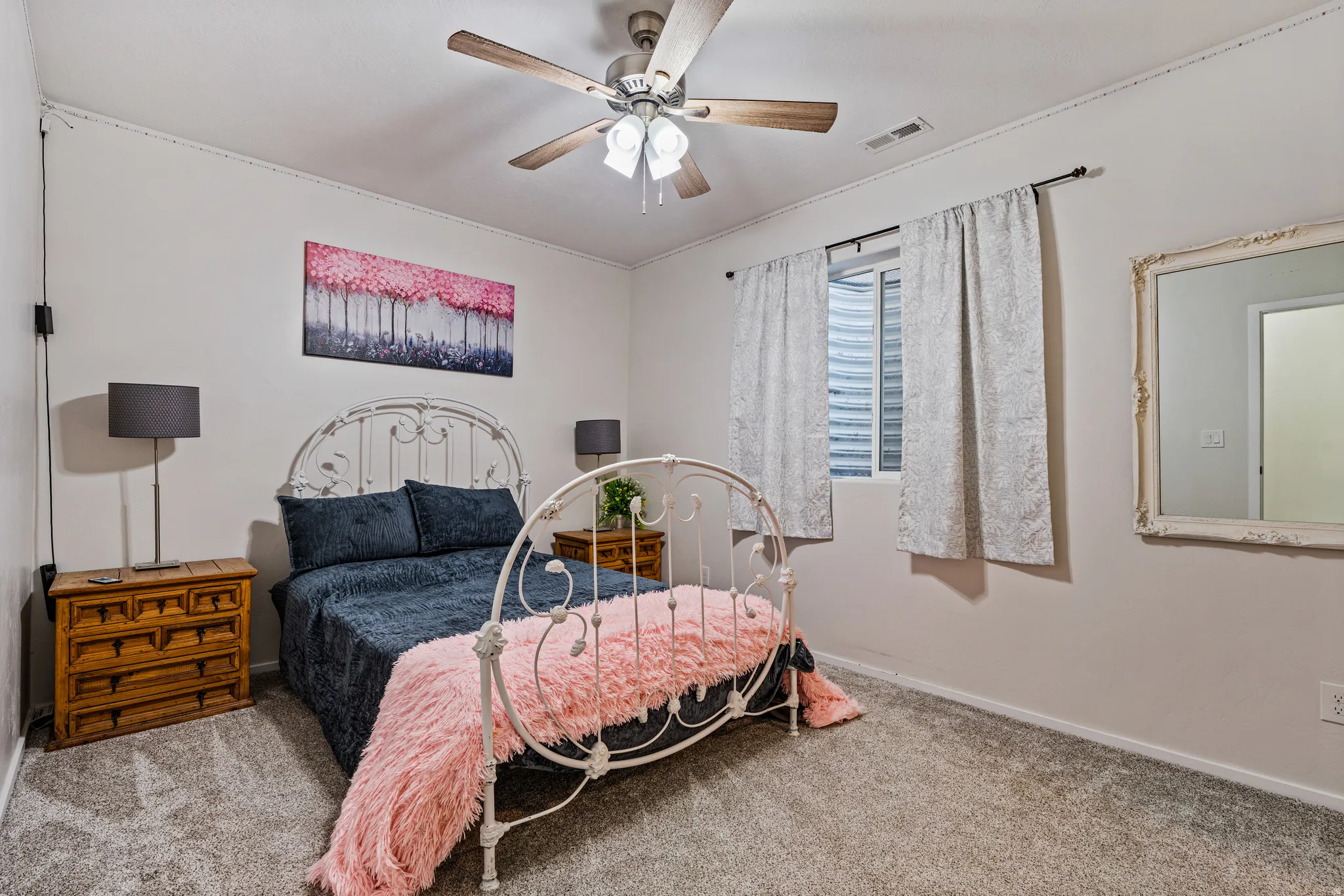 Room featuring neutral wall tones, textured carpet, and a ceiling fan with integrated lighting