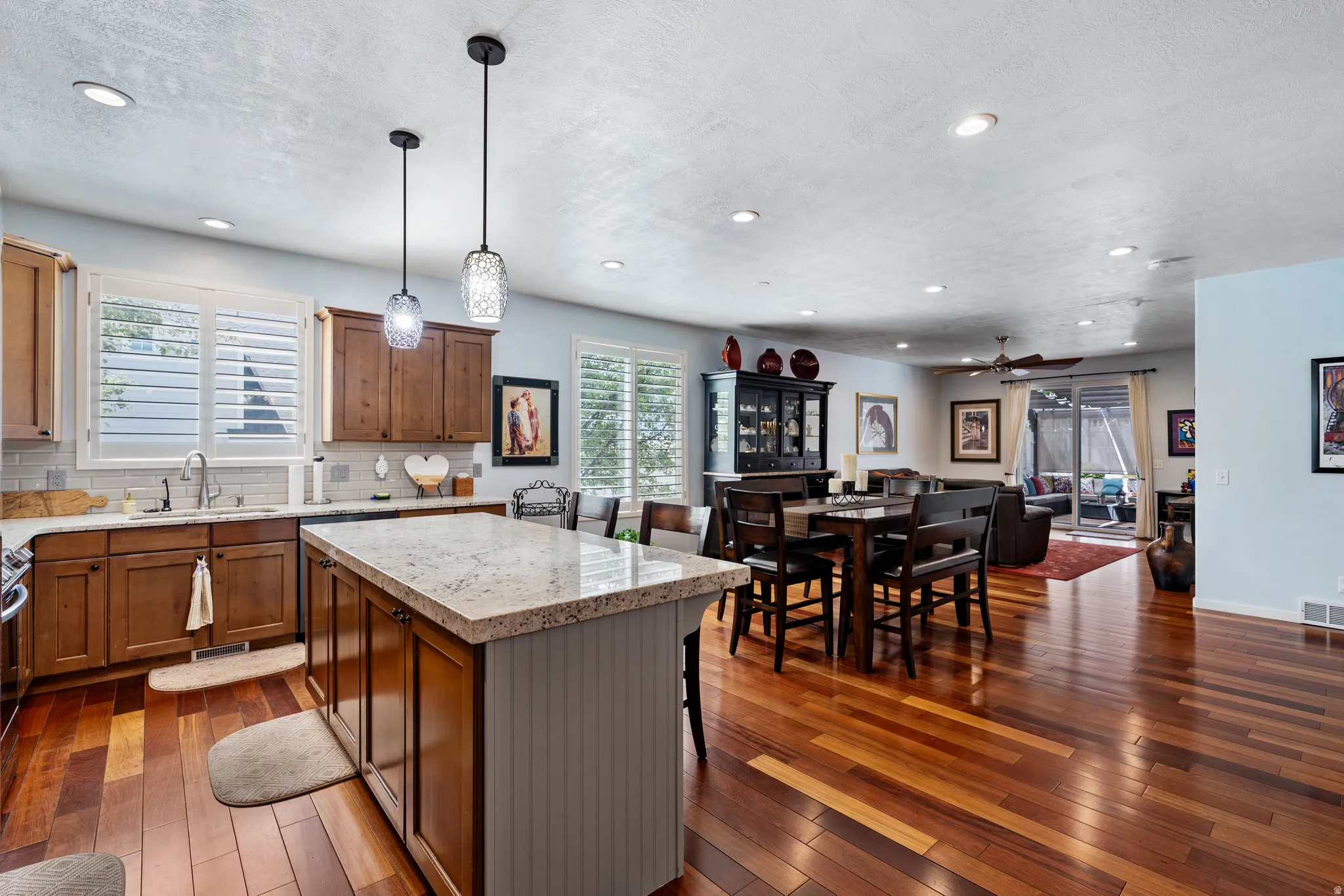 Open-concept kitchen and living area featuring warm wood-finish flooring