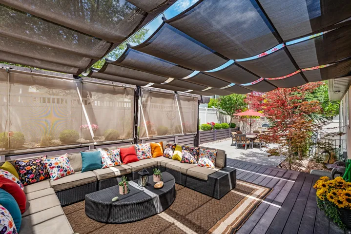 Outdoor deck featuring a retractable shade canopy and privacy screens