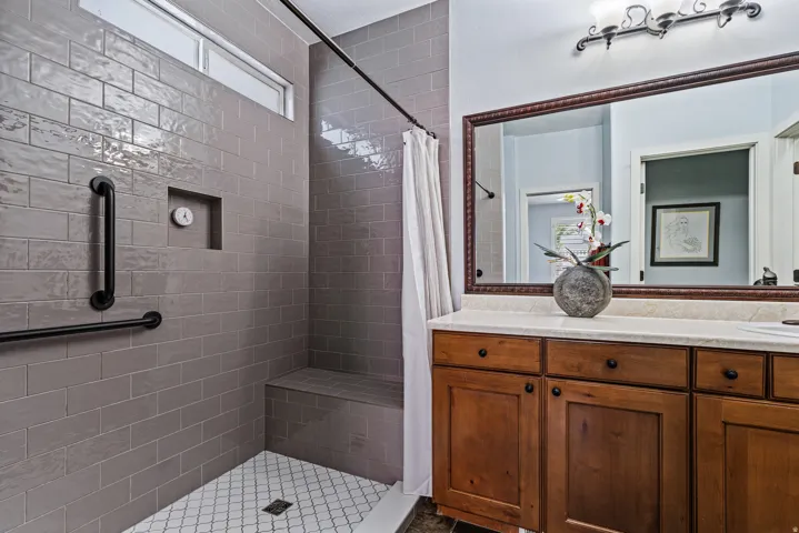 Bathroom featuring a walk-in shower with gray subway tile, a built-in shower bench, and a tiled shower niche