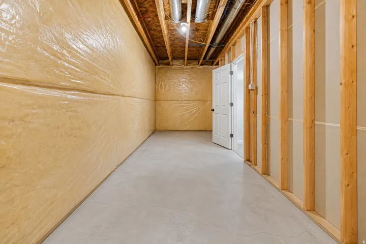 Unfinished basement featuring exposed wood joists and concrete flooring