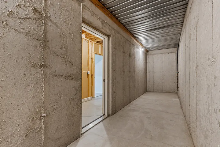 Unfinished basement space featuring concrete walls, a concrete floor, and a metal ceiling