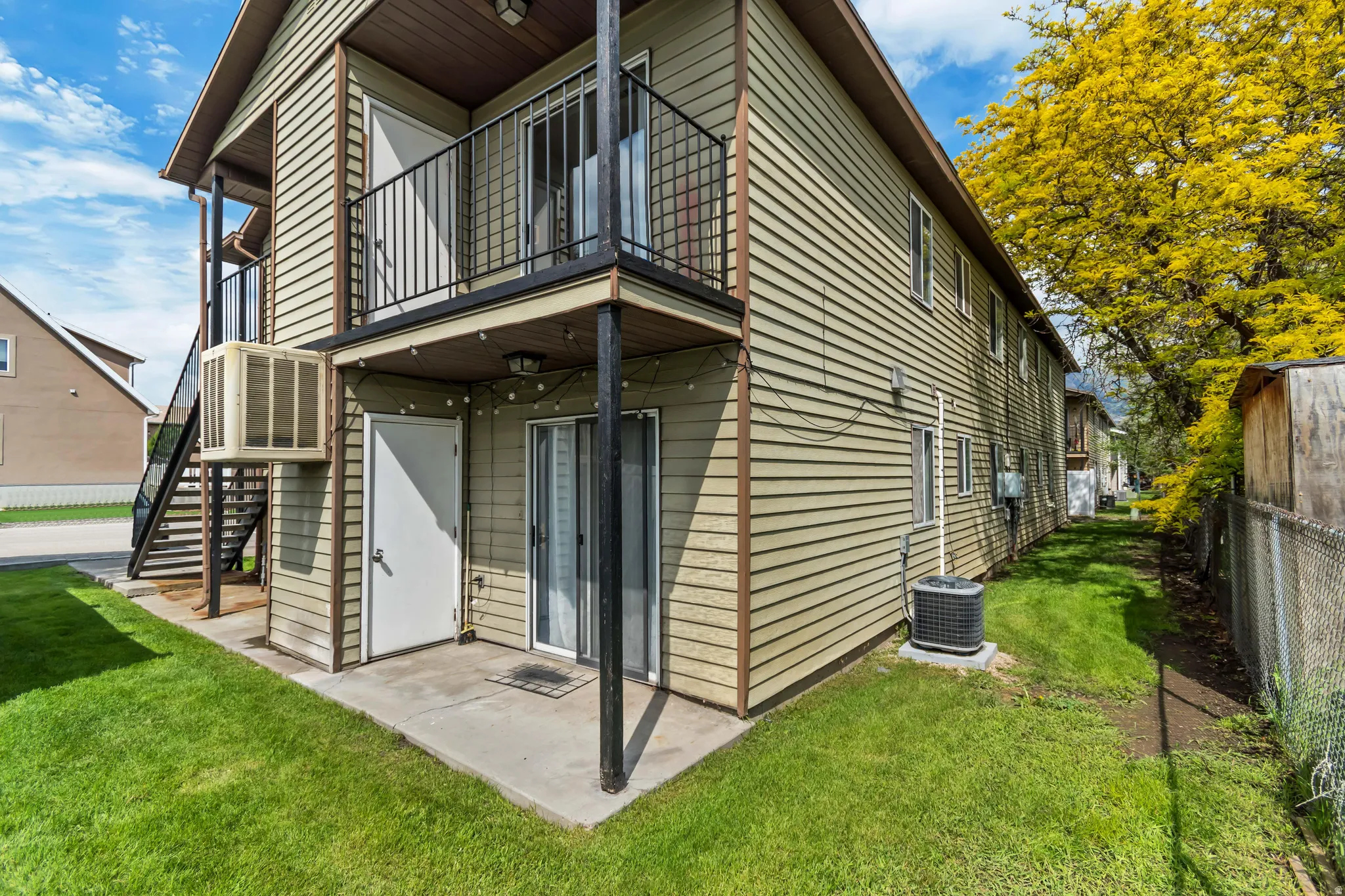 Two-story structure with horizontal siding and a ground-level concrete patio