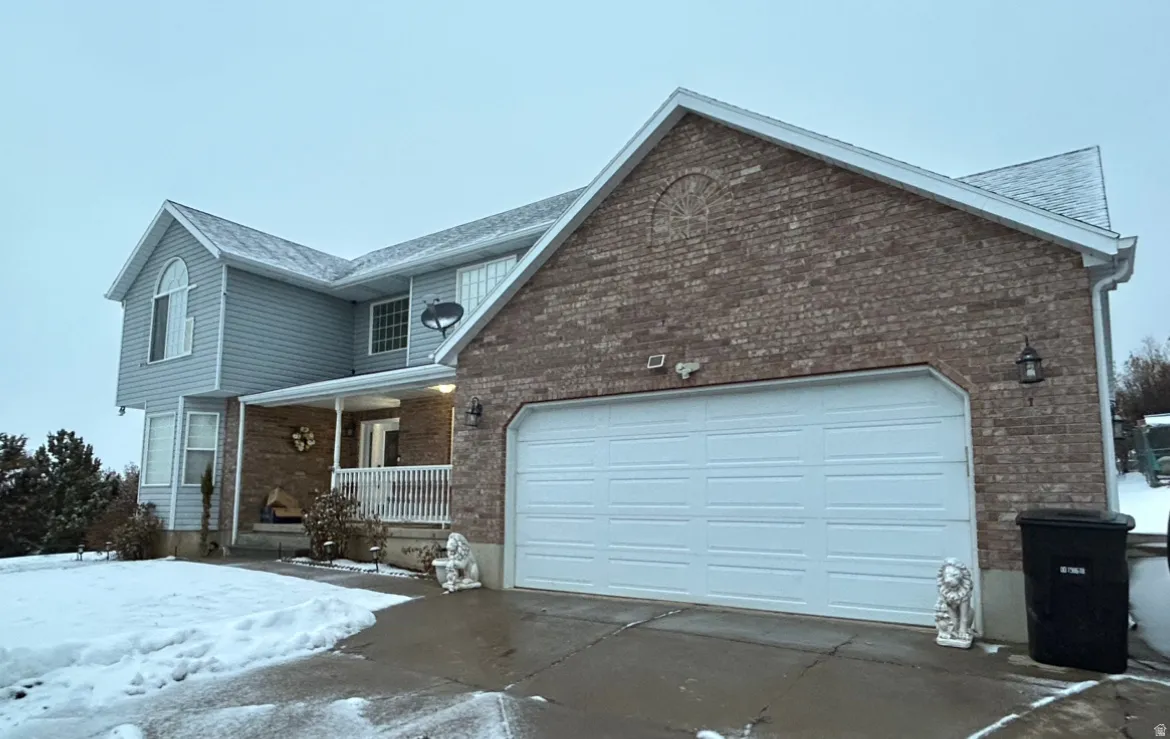 Brick and siding exterior featuring a two-car garage with a paneled door