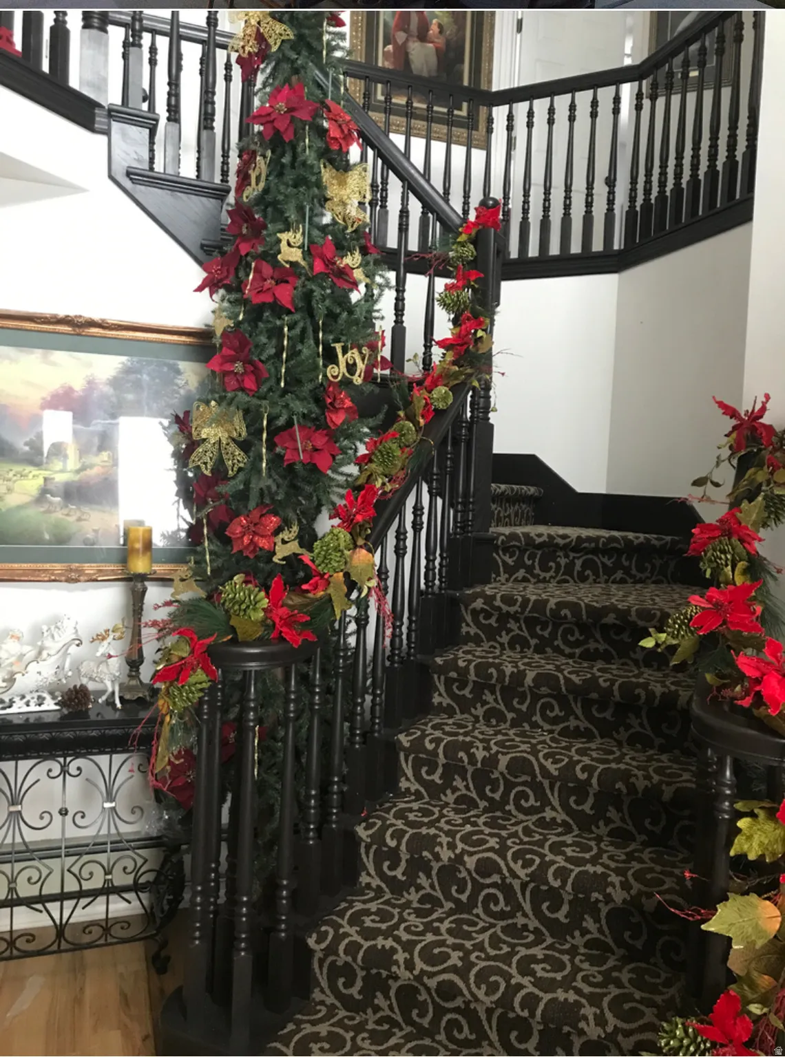 Grand staircase featuring dark wood newel posts and balusters
