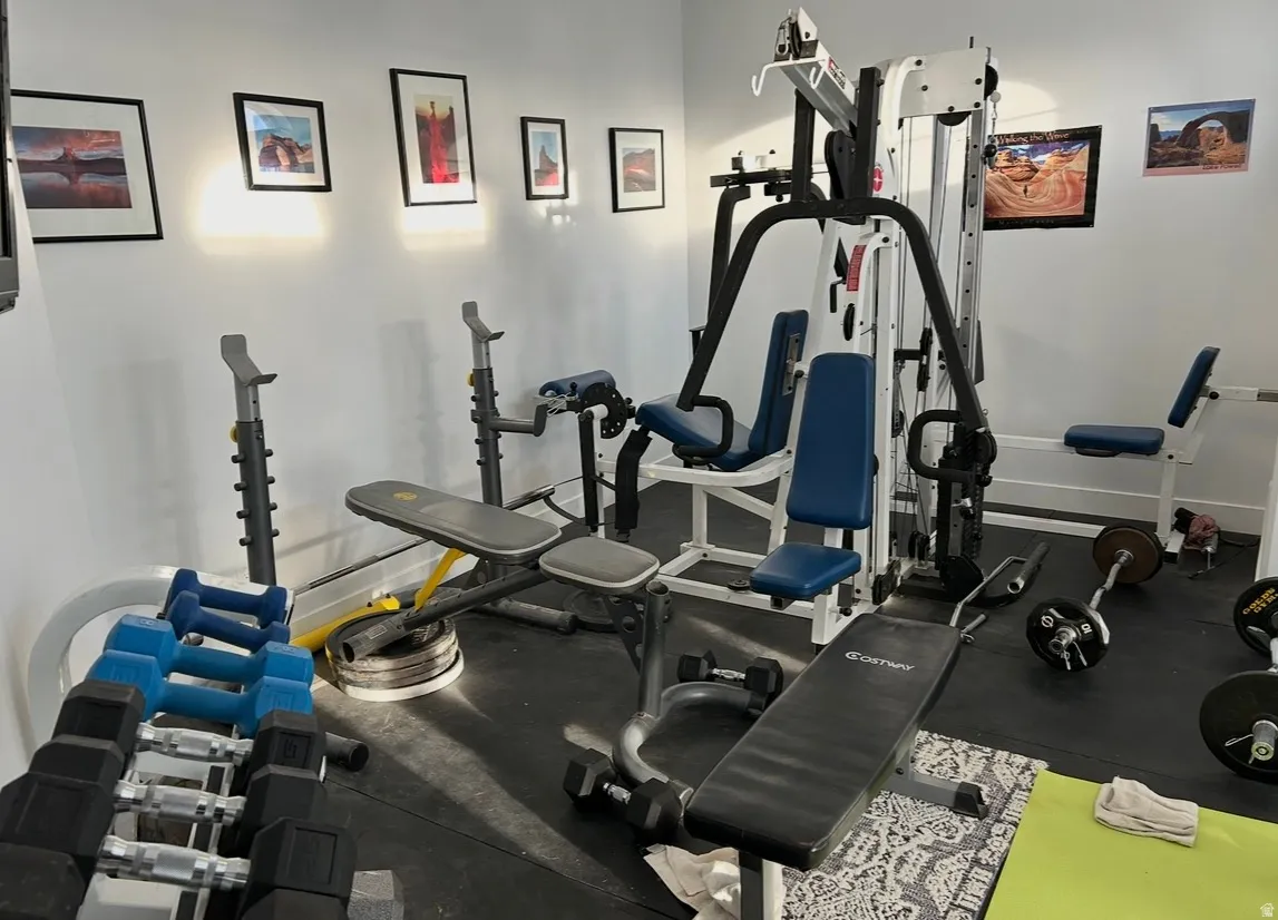 Dedicated fitness space featuring rubber flooring, white walls, and recessed lighting