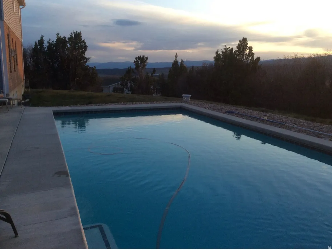 Rectangular inground pool featuring a concrete surround and integrated steps