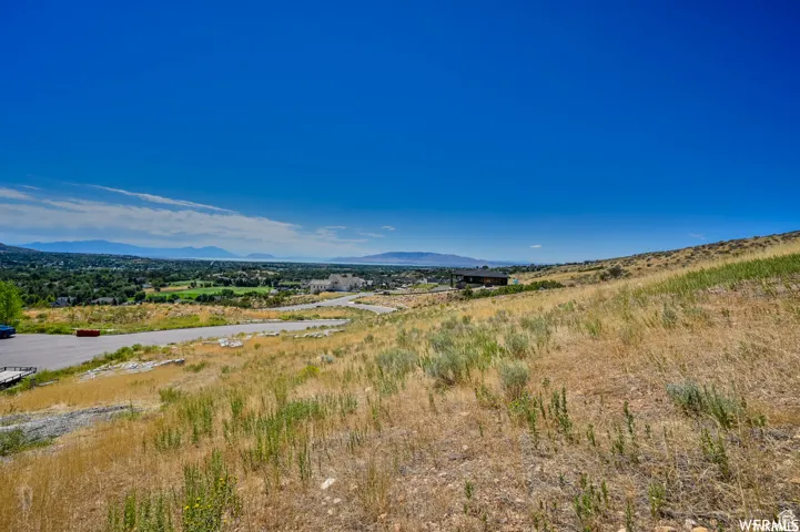 Expansive hillside property with distant mountain range and valley terrain