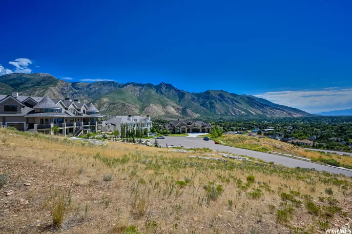 Expansive land parcel with surrounding mountain scenery and established residential architecture