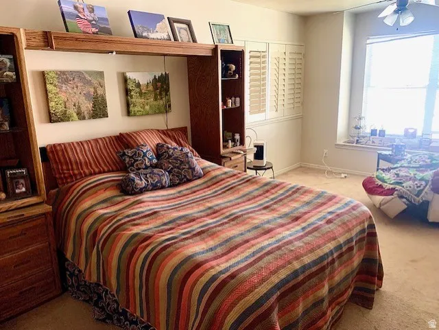 Bedroom with an integrated wood-finish storage unit featuring open shelving and drawers