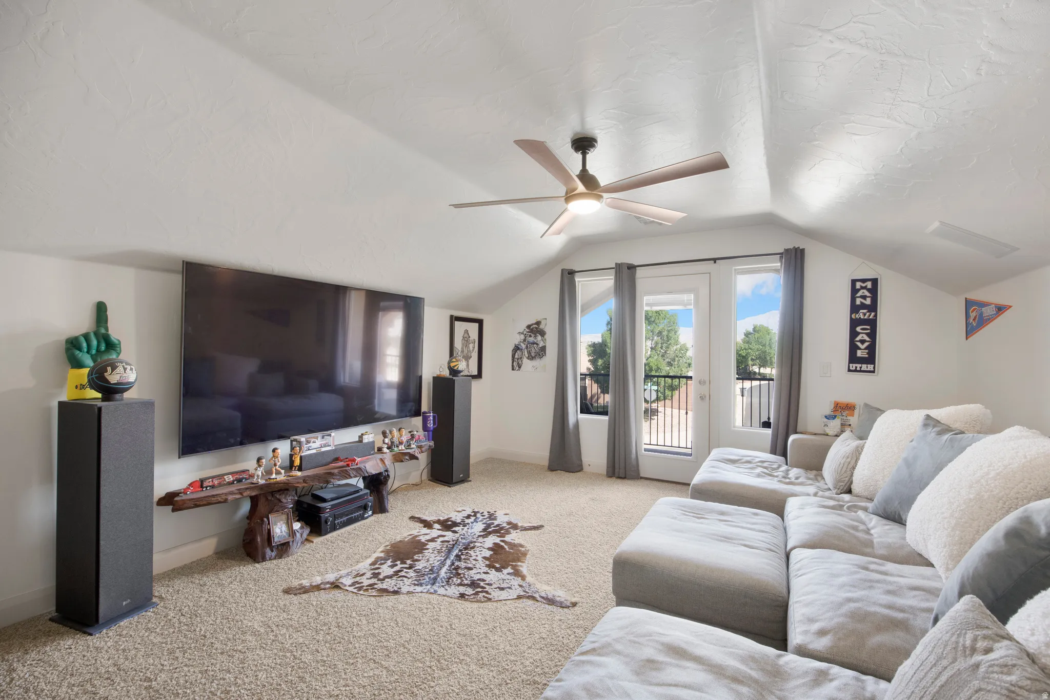 Spacious bonus room featuring vaulted ceilings, a ceiling fan with integrated lighting, and carpeted flooring