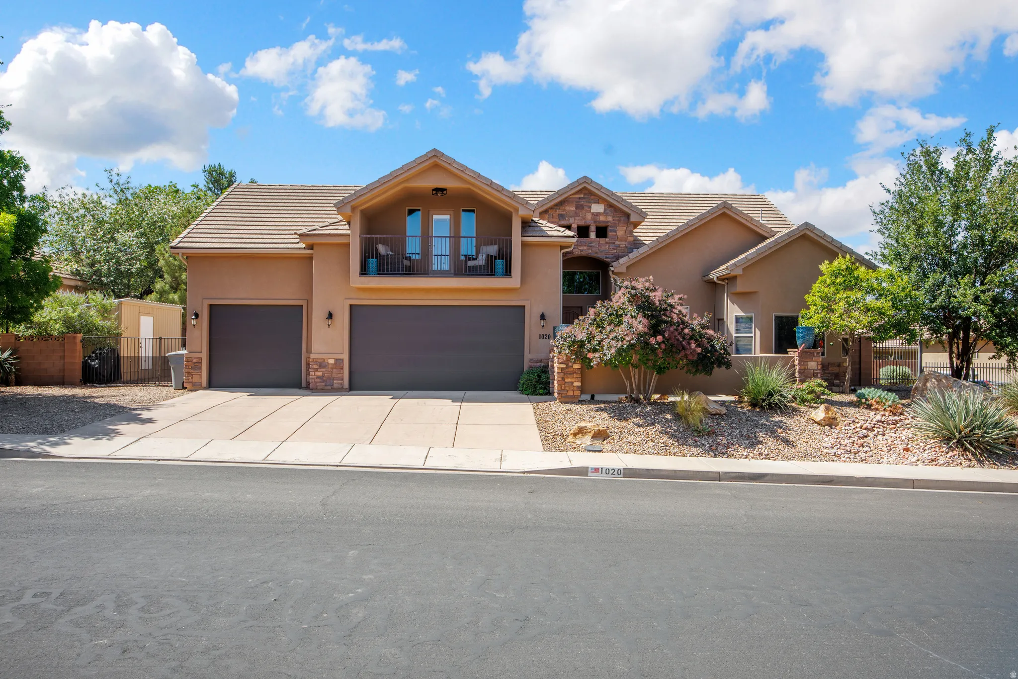 Stucco exterior featuring stone accents and a tiled roof