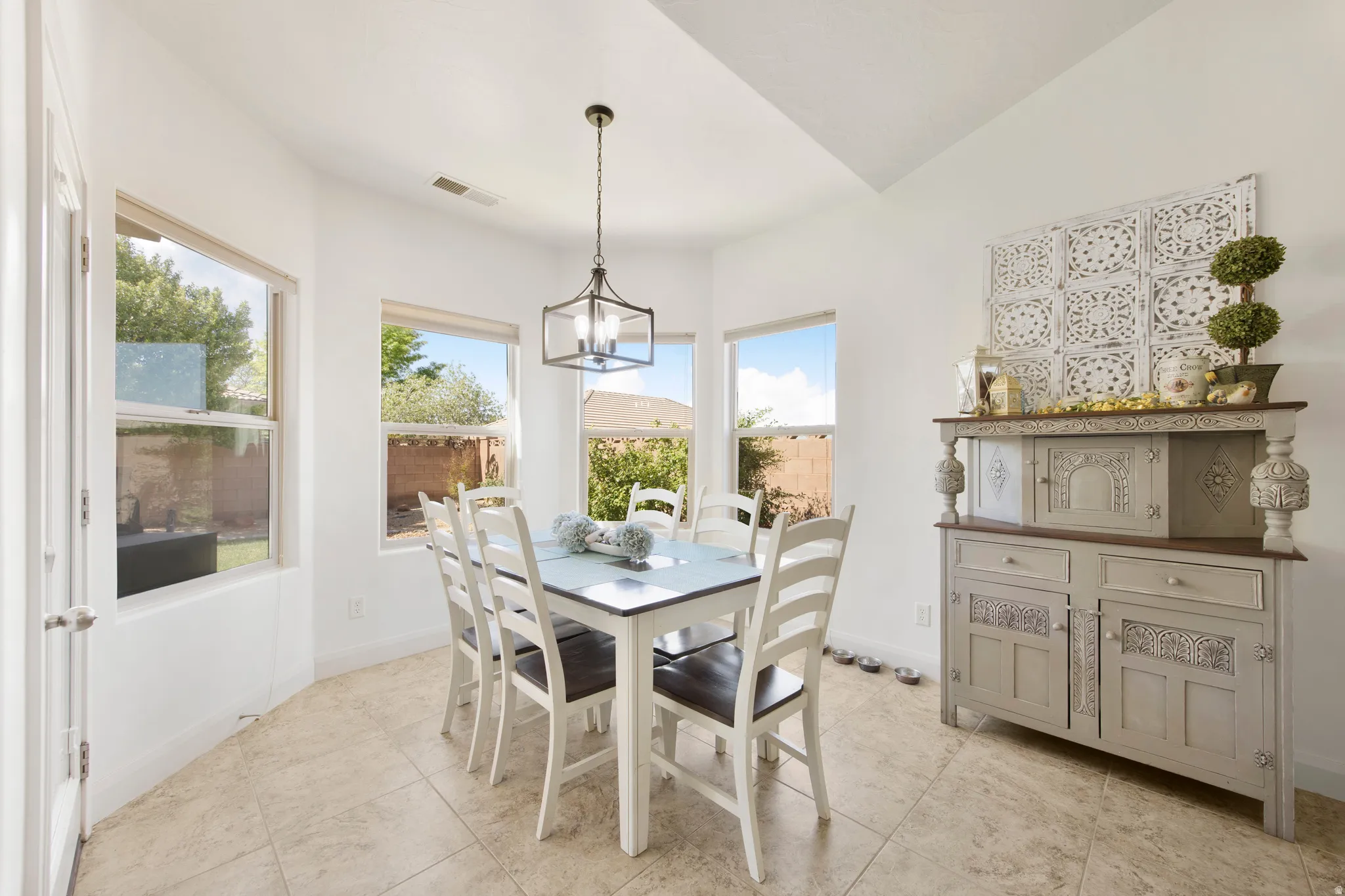 Dining area featuring a contemporary chandelier, multiple windows, and tile flooring